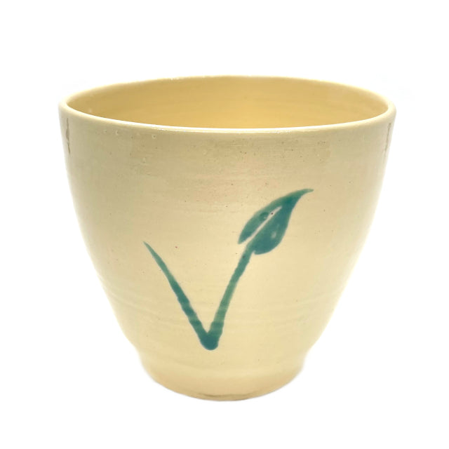 handmade ceramic mug features a green flower 